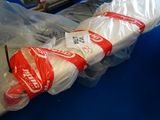 un grand parapluie blanc emballé dans du plastique, posé sur une table