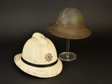 pair of hats and a hat stand on a black surface