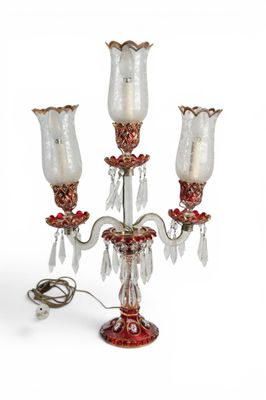 un bougeoir rouge et blanc orné de trois fleurs en verre
