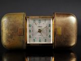 a gold case with a clock inside of it on a table
