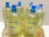 quatre flacons de savon pour les mains Bioderma posés sur un plateau en bois