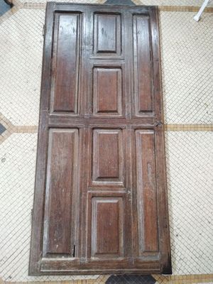 une porte en bois posée à même le sol dans une pièce