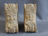 paire de serre-livres en pierre sculptée représentant les visages d'un homme et d'une femme