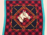 une image représentant une tête de cheval sur une couverture à carreaux rouges et noirs