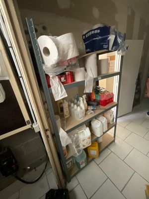 a man that is standing in a bathroom next to a shelf