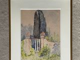 framed watercolor painting of a stone wall with a building in the background