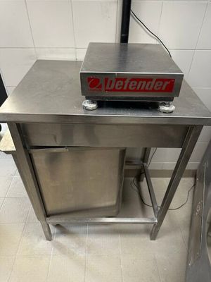 une table en acier inoxydable sur laquelle est posée une pancarte