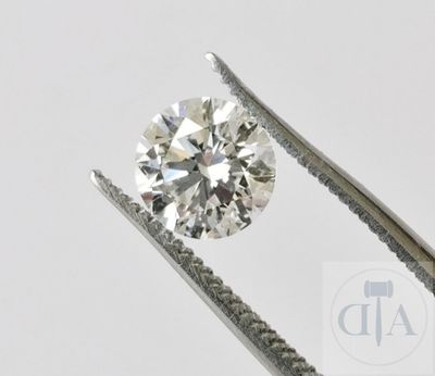 un gros plan d'un diamant tenu par une paire de pinces