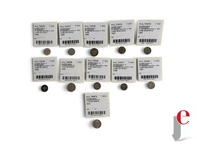 plusieurs types de pièces de monnaie sont disposés sur une surface blanche
