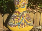 a large yellow vase sitting on the side of the road