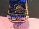 a blue and gold vase sitting on a pink table