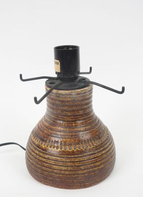 une image représentant un vase marron avec un couvercle noir sur fond blanc