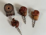 three wine bottle openers and a cork opener on a table