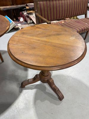 several chairs and a table in a room with a lot of furniture in the background