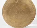 a gold plate with a design on it on a white surface