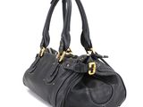 a black leather handbag with gold hardware on the handles