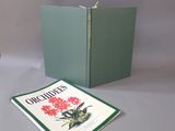 un livre vert sur lequel figure l'image d'une fleur rouge