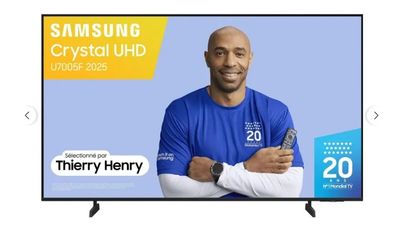 un homme debout devant un téléviseur sur lequel figure le logo « Samsung Crystal UHD »