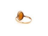a close up of a gold ring with an orange stone