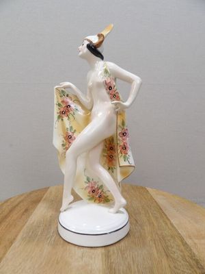 une figurine représentant une femme posée sur une table en bois