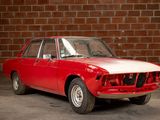 a red car that is parked in front of a brick wall