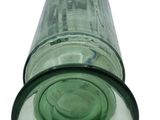 a green glass bottle sitting on top of a white surface