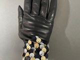 a person wearing a black leather glove and a black and white polka dot wrist band