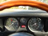 a close up of a car dashboard with gauges and a steering wheel
