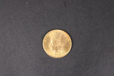 gros plan d'une pièce d'or sur une surface noire