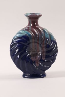 a blue and red vase sitting on a white surface
