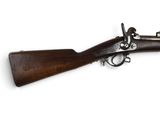 un vieux fusil avec un canon en bois et une poignée en bois