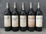 six bouteilles de vin sont alignées sur une table