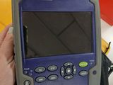 purple and gray handheld computer sitting on top of a black bag