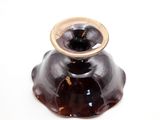 a brown vase with a gold ring on top of it