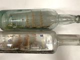 two empty glass bottles that are sitting on a table