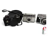 three cameras sitting next to each other on a white surface