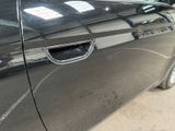 a black car parked in a garage with its door open