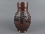 a brown vase sitting on a table with a gray background