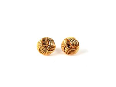 une paire de boucles d'oreilles dorées sur fond blanc