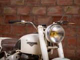a white motorcycle parked in front of a brick wall