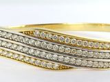 gros plan d'une bague en or et diamants sur une surface blanche