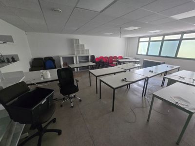 des tables et des chaises dans une pièce donnant sur une grande fenêtre