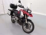 une moto rouge et noire garée dans une pièce blanche