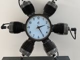 une horloge composée de quatre pièces de moteur montées sur un socle
