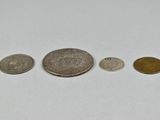 a close up of three different coins on a white surface