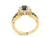 a close up of a gold ring with a sapphire and diamonds