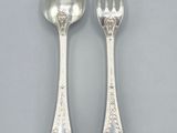 two silver spoons and a fork on a white surface