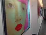 a picture of a woman ' s face on the wall in a hallway