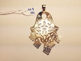 an image of a gold pendant with filigree filigrees on it