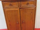 a small wooden cabinet with two drawers on top of it